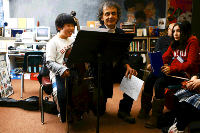 A composer helps a student with his cello in a classroom crowded with books and computers. A library of images for a town can help promote its image, drawing residents, businesses and visitors.
