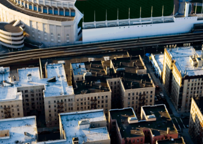 Aerial view of Yankee Stadium in late afternoon, with the rooftops of the Bronx neighborhood in the foreground. New York City photo by Suzy Allman, a travel and tourism photographer.
