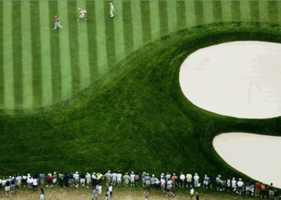 Aerial view of the 17th green at Winged Foot Country Club in Mamaroneck, New York, showing green, sand trap bunkers, players and gallery.