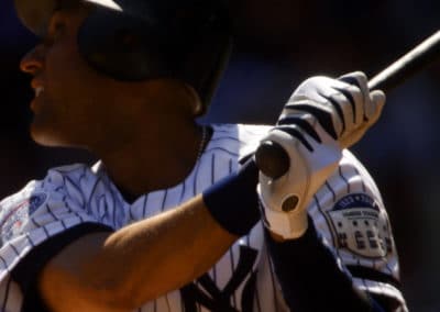Sports photo of Derek Jeter swinging the bat in a close-up in the late afternoon slanted sunlight.